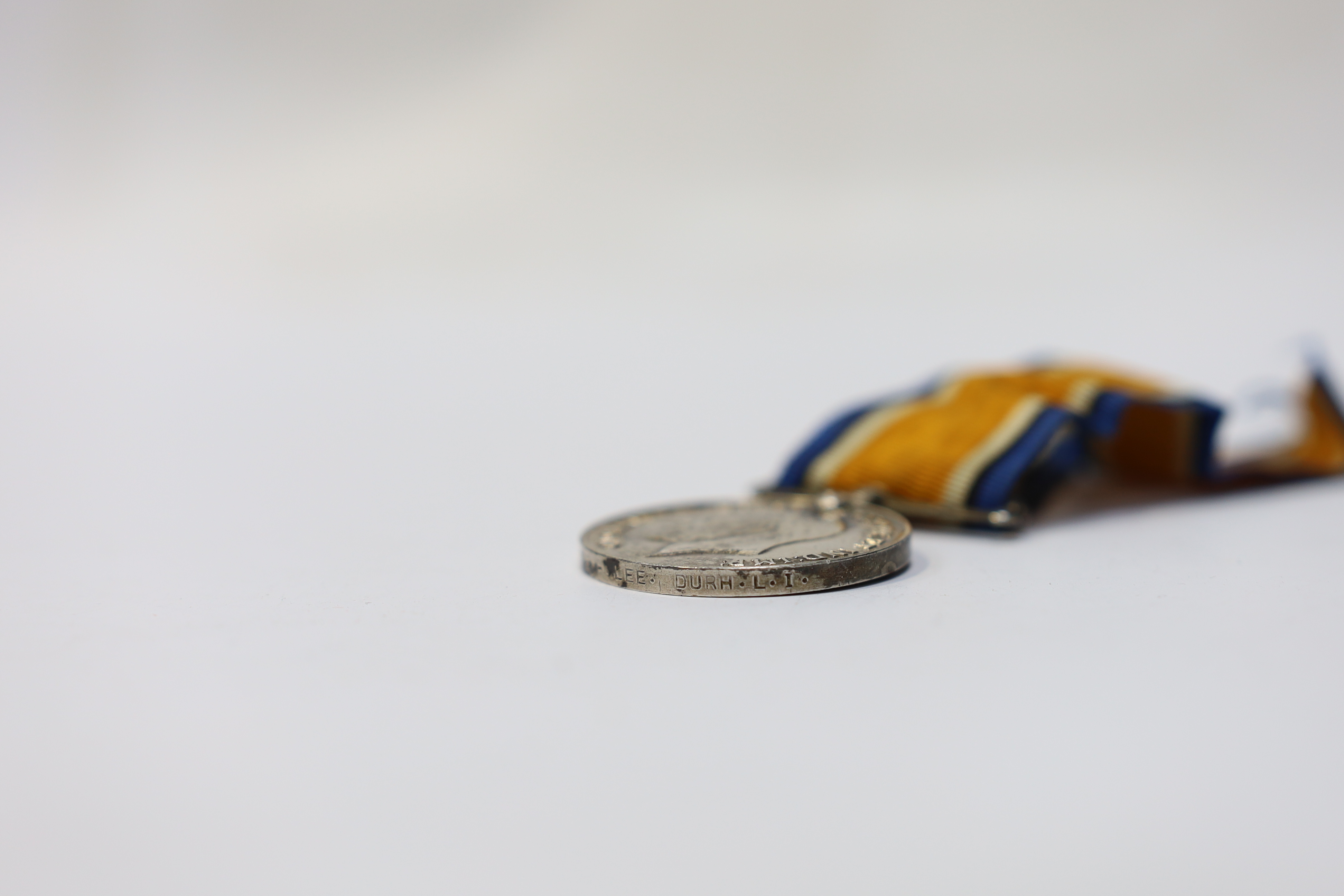 Seven medals including; a First World War British War Medal awarded to PTE. H. Lee DURH. L.I., A 1939-1945 medal, The Defence Medal, the Africa Star, the France and Germany Star, the 1939-1945 Star, plus a GPO cap badge.